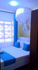 Makasembo furnished apartments one bedroom في كيزيمو: غرفة نوم بسرير ومخدات زرقاء واضاءة