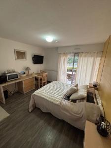 ein Schlafzimmer mit Bett, Schreibtisch und Fenster in der Unterkunft Studio 7 in Balaruc-les-Bains