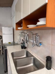 uma cozinha com um lavatório e armários de aço inoxidável em Primo`s 2 Suites & Hostel em Búzios mais 48 fotografias