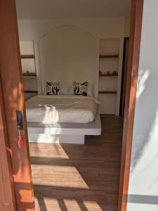 een slaapkamer met een bed en een houten vloer bij CozyShell in General Luna