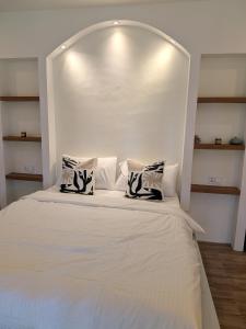 een wit bed met twee kussens erop bij CozyShell in General Luna