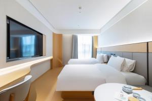 Jiangning全季酒店（南京百家湖1912店）的一间配有两张床和一台平板电视的酒店房间