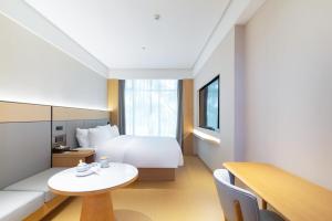 Jiangning全季酒店（南京百家湖1912店）的一间带床和桌子的酒店房间