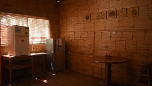 AquamarInn في مانكورا: مطبخ مع ثلاجة وطاولة في الغرفة