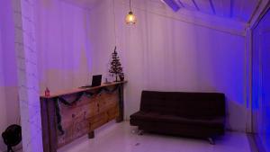 uma sala de estar com uma cadeira e uma árvore de Natal em Primo`s 2 Suites & Hostel em Búzios