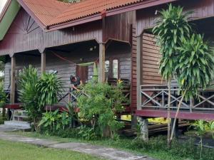 a house with a person standing outside of it at Boune Hom Guesthouse Sunrise Don Det in Don Det