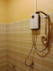 a shower in a bathroom with a shower head at Boune Hom Guesthouse Sunrise Don Det in Don Det +3 photos