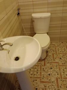 a bathroom with a white sink and a toilet at Boune Hom Guesthouse Sunrise Don Det in Don Det