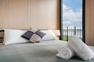 a bedroom with a bed with pillows and a window at Aorangi Peak Cabins 1 by Tiny Away in Rotorua