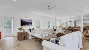 a living room with white furniture and a table at 6 36th Avenue by AvantStay Stunning Private Pool in Isle of Palms