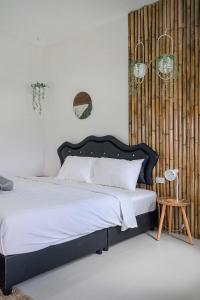 ein Schlafzimmer mit einem großen Bett mit schwarzem Kopfteil in der Unterkunft Cozy Seaview Studio 50 Meters From the Beach in Ko Kong Nui