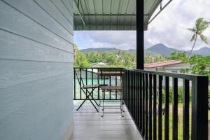 ein Balkon eines Hauses mit einem Tisch und Stühlen in der Unterkunft Cozy Seaview Studio 50 Meters From the Beach in Ko Kong Nui