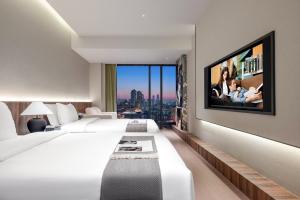 Una habitación de hotel con una cama grande y un televisor. en Chongqing Bert High-Altitude Hotel Jiangbeizui Financial Center Branch, en Chongqing