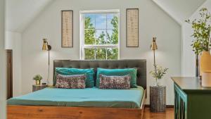 a bed with blue pillows in a room with a window at Mountain Mindset by AvantStay Pool Hot Tub Game Room Firepit in Long Pond +45 photos