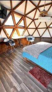 a bedroom with a bed and two chairs in a yurt at Hostal y Domos Bello Horizonte in Villarrica