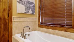 Una bañera blanca en un baño con ventana. en Steps to Lifts Peak 9 Main Street Balcony Lounge Pool Water House 5204 by AvantStay, en Breckenridge 17 fotos más