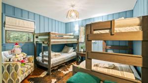 a room with two bunk beds and a couch at The Horseshoe Hideaway Lake Harmony Cabin w Hot Tub Game Porch in Lake Harmony