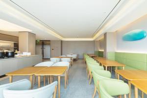 Jiangning全季酒店（南京百家湖1912店）的配有木桌和白色椅子的餐厅