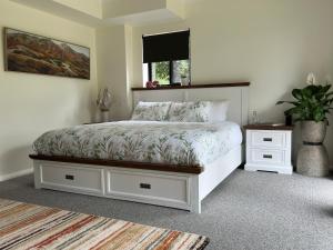 Ein Schlafzimmer mit einem weißen Bett und einer Pflanze auf einem Teppich in der Unterkunft Tatra Studio Bright - Relax & Explore in Bright