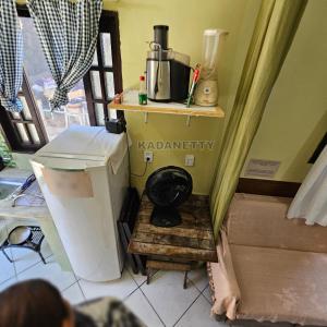 een keuken met een koffiezetapparaat op een houten plank bij Casa Ventilada e Confortável, Perto da Rodovia e 2km da Praia in Caraguatatuba