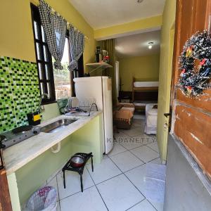 een keuken met een spoelbak en een koelkast bij Casa Ventilada e Confortável, Perto da Rodovia e 2km da Praia in Caraguatatuba