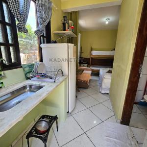 een keuken met een spoelbak en een koelkast bij Casa Ventilada e Confortável, Perto da Rodovia e 2km da Praia in Caraguatatuba +15 foto's