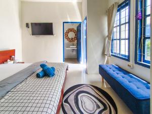 a bedroom with two beds and a tv in it at The Lavana Rumah Keboon in Mataram +47 photos