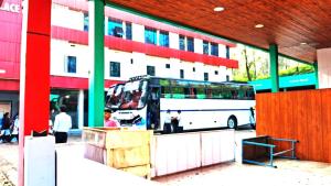 un autobús está estacionado frente a un edificio en Hill palace Inn, en Periya