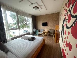 大叻Redhouse Dalat Hotel的一间卧室，里面有一张床和一扇大窗户。