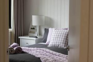 a bedroom with a bed with a pillow and a lamp at Lakes Edge 4 in Wendouree