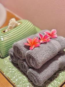 a pile of towels with flowers on top of them at AMANA ayurveda in Kami Amakusa +83 photos