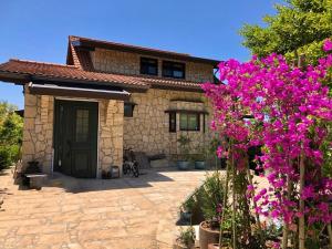 a house with purple flowers in front of it at AMANA ayurveda in Kami Amakusa
