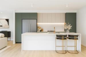 una cucina con bancone bianco e 2 sgabelli da bar di Rochedale Outlook a Rochedale Altre 5 foto