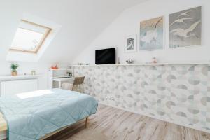 a bedroom with a bed and a tv on a wall at Cozy Attic in Marki +5 photos