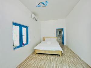 a white room with a bed and a window at Ben's House 2 in Tam Ky