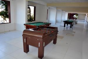 Dos mesas de billar en una habitación con paredes blancas. en FLAT MONTE CASTELO CONDOMÍNIO GRAVATÁ NA FRENTE DA ÁREA DE LAZER - Pe, en Sairé