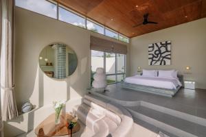 a bedroom with a bed and a mirror at The Outside Design Suites in Uluwatu