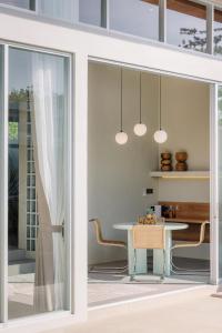 a glass door leading to a dining room with a table at The Outside Design Suites in Uluwatu