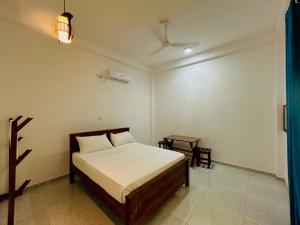 a bedroom with a bed and a table in it at Blue Heaven Main in Wellawaya