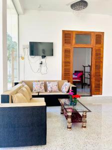 a living room with a couch and a table at Blue Heaven Main in Wellawaya