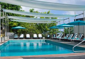 a swimming pool with umbrellas in the middle of the pool at Bel Jou Adults Only - All Inclusive in Castries