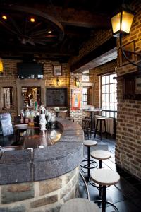 a bar in a restaurant with tables and stools at Les Suites de Nanesse in Liège