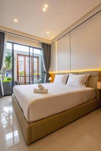 a bedroom with a large bed and a large window at Dâu Tây Villa in Da Nang