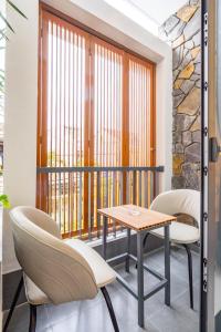 a balcony with a table and chairs and a window at Dâu Tây Villa in Da Nang
