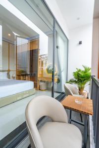 a room with a bed and two chairs and a table at Dâu Tây Villa in Da Nang +52 photos