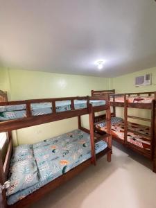 ein Zimmer mit drei Etagenbetten in einem Zimmer in der Unterkunft ACA Transient House in Nasugbu