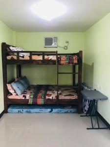 a room with two bunk beds and a desk at ACA Transient House in Nasugbu