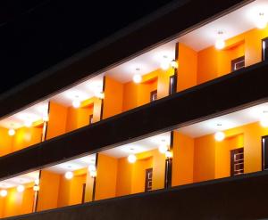 a row of yellow apartment buildings with lights at Hotel Los Arcos in Santa María Nopaltepec