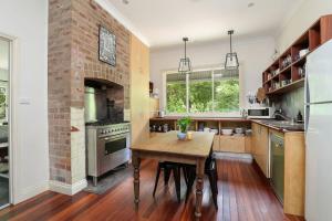a kitchen with a wooden table and a brick fireplace at Finchley in Blackheath