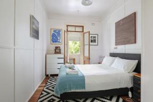 a bedroom with a large white bed and a window at Finchley in Blackheath